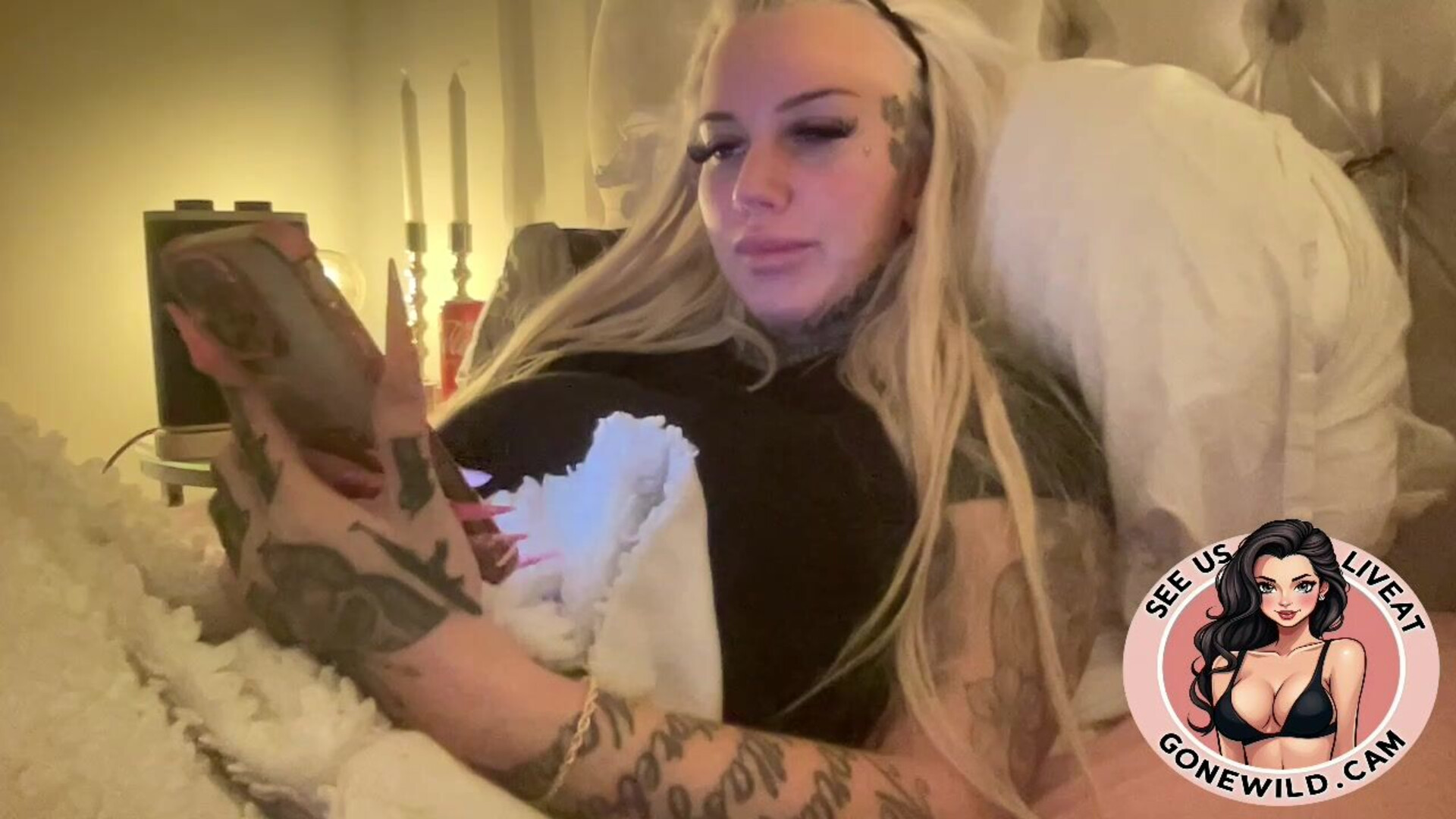 Inked Blonde Bombshell Holding Toys in Bed - tattoo - blonde - solo - tease - bedroom - toys - long nails - inked - masturbation - softcore